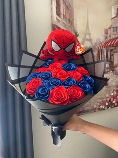 a person holding a bouquet of roses in front of a wall with a spiderman on it