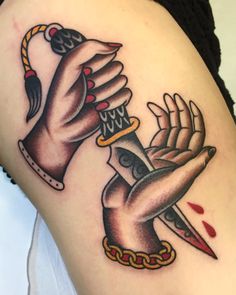 a woman's arm with tattoos on it and two hands holding a knife in the middle