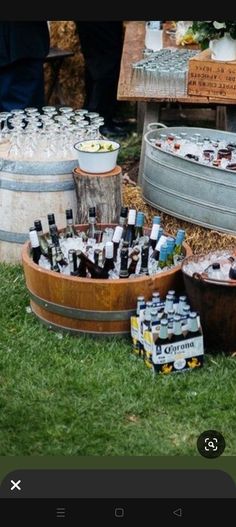 several wooden buckets filled with bottles on top of grass