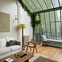 a living room filled with furniture and plants