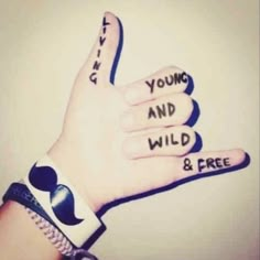 a person's hand with two fingers that say you and wild and free on it