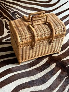 a wicker box sitting on top of a zebra print rug