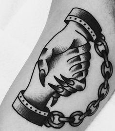 a black and white photo of a hand holding a chain tattoo on the left arm