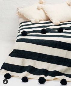 a black and white striped bed with pom - poms