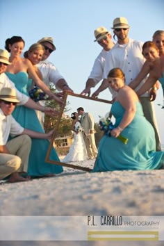 a group of people standing on top of a beach next to each other holding a mirror