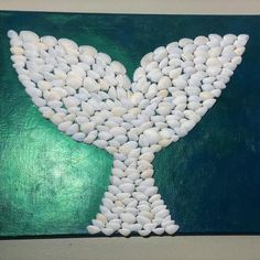 a painting with white rocks in the shape of a whale's tail on a green background