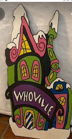 a wooden sign that says whoville on the front and side of it with a house in the middle