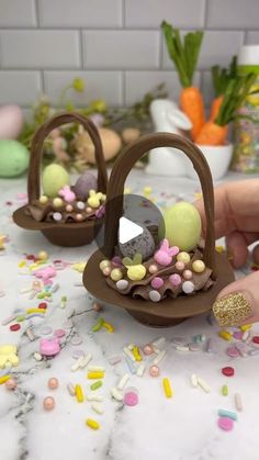 someone is decorating small baskets with candy