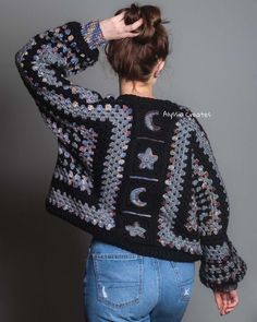 a woman is wearing a black sweater with crochet and beads on the back