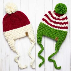 two knitted hats with pom - poms on white wooden boards, one green and the other red