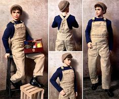 a boy in overalls and hat standing next to a wall