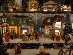 a christmas village with people and buildings in the snow