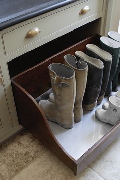 several pairs of boots are lined up on a shelf