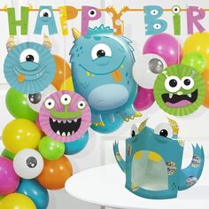 a birthday party with balloons, paper monsters and streamers in the shape of animals