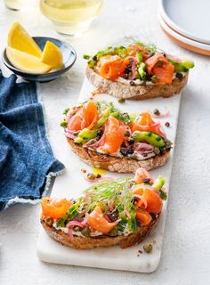 three slices of bread topped with salmon and veggies