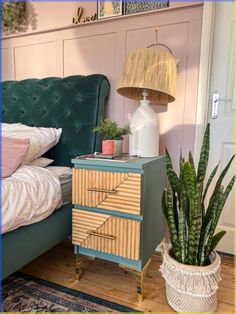 a bedroom with a bed, nightstand and potted plant