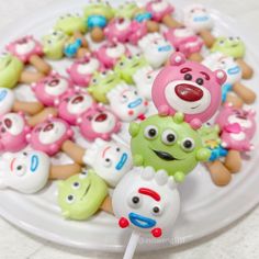 there are many different colored candies on the plate and one is holding a toothbrush