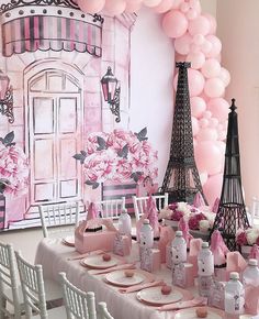 a table set up with pink and white decorations, balloons, and decor items for a paris themed birthday party