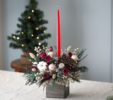 a christmas centerpiece with two red candles