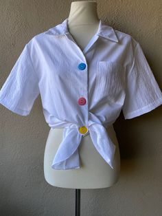 "Pastel Button blouse. Pair with your favorite pair of vintage jeans!  --- Condition: Great vintage condition  --- Size: tags lists small but fits like a M.  Shown on size small mannequin with 26\" waist and 34\" bust and fits is slightly oversized  --- @bluehoneyshop" Retro Buttoned Tops For Day Out, Retro Tops With Buttons For Day Out, Retro Button-up Blouse For Day Out, Vintage Tops With Buttons For Day Out, Casual Vintage Tops With Buttons, Vintage Buttoned Top For Day Out, Cropped Cotton Blouse With Buttons, Retro Button-up Shirt For Day Out, Retro White Tops With Buttons