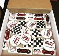 a box filled with cookies covered in white icing and black and red designs on top of each other