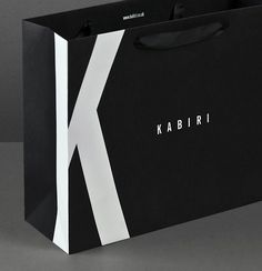 a black and white shopping bag with the letter k on it's front side