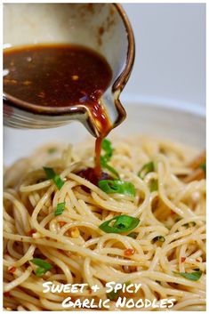 someone is pouring sauce on some noodles in a bowl