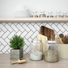 kitchen utensils and wooden cutting boards sit on a countertop in front of white tiled backsplash