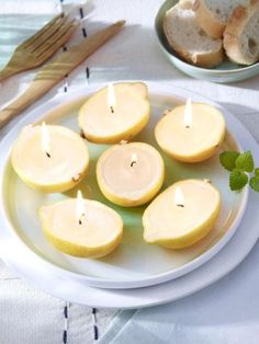 apples cut in half on a white plate with green leaves and bread slices behind them