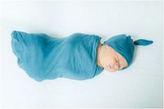 a baby wearing a blue hat and sleeping