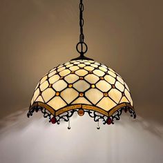 a stained glass light fixture hanging from a ceiling