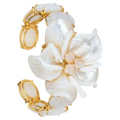 The Cassie Cuff, crafted from semi-precious stones, showcases a unique and sizable flower at its center, embodying the distinctiveness of our brand. Its vintage-style design adds to its allure. SKU: CF-FL-31 Stones: White Coral, Mother of Pearl & Moonstone Material: 14K Gold Plated Dimensions: 2" Luxury Flower Jewelry For Evening, Luxury Flower-shaped Jewelry For Evening, Luxury Flower-shaped Evening Jewelry, Luxury Gemstone Cuff Bracelet For Weddings, Elegant Gemstone Cuff Bracelet For Wedding, Handmade Luxury Flower Shaped Jewelry, Elegant White Gemstone Cuff Bracelet, Elegant Flower Shaped Cuff Bracelet, Elegant Flower Cuff Bracelet