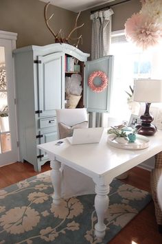 a white table sitting on top of a rug in a living room next to a window