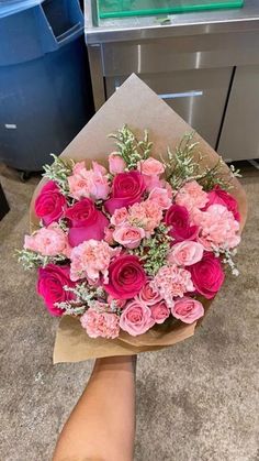 someone holding a bouquet of pink flowers in their hand