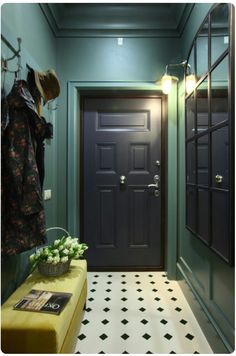 a room with a black door and green walls