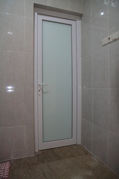 an open door in a tiled room with wood flooring and tile wall coverings