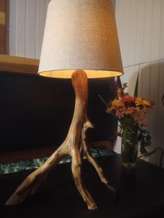 a lamp that is on top of a table next to a vase with flowers in it