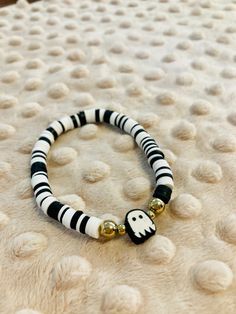 Enjoy this beautiful black and white hand-crafted bracelet with clay beads and a white ghost central charm.. Bracelet is elastic banded and stretches to fit an average size female wrist. Celebrate fall and Halloween with this fun jewelry. White Beaded Bracelets For Halloween, White Beaded Novelty Stretch Bracelet, White Novelty Beaded Stretch Bracelet, White Beaded Bracelets For Halloween Gift, Handmade White Beaded Bracelets For Halloween, White Adjustable Jewelry For Halloween, Adjustable White Jewelry For Halloween, Bracelet With Clay Beads, Clay Bracelets