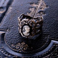 Victorian style antiqued sterling silver plate filigree ring which is fully adjustable.At its center is a 10x8mm black and white womans profile cameo. Womans Profile, White Lady, Purple Lady, Book Locket, Cameo Jewelry, Cameo Ring, Dope Jewelry, Cameo Necklace, Filigree Ring