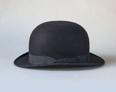 Black Derby Hat With Short Brim, Black Short Brim Hat For Derby, Classic Cloche Hat With Flat Brim For Formal Occasions, Classic Black Hat For Derby, Classic Formal Cloche Hat With Flat Brim, Black Brimmed Top Hat For Derby, Classic Adjustable Hats For Derby, Classic Adjustable Hat For Derby, Black Top Hat For Derby