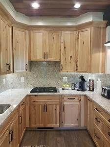 a kitchen filled with wooden cabinets and white counter tops next to a stove top oven