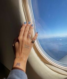 a woman's hand on the wing of an airplane