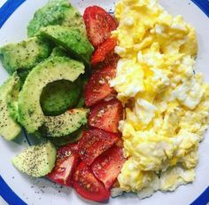 a plate with eggs, avocado, strawberries and tomato slices on it