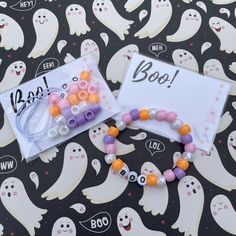 two bracelets that say boo on them and one with beads in the shape of ghostes