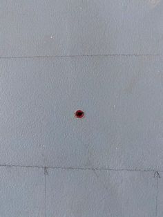 a red spot on the side of a white wall