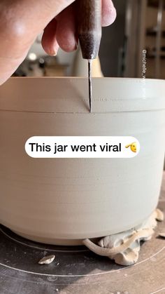 a person using a sharp knife to cut into a bowl with the words'this jar went virtual'on it