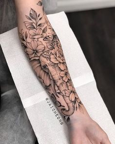 a woman's arm with an elephant and flowers on it