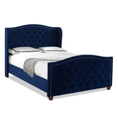 a blue bed frame with buttons on the headboard and foot board is upholstered