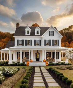 a large white house with lots of windows on the front and side of it, surrounded by hedges