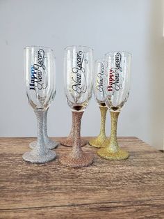 three wine glasses sitting on top of a wooden table